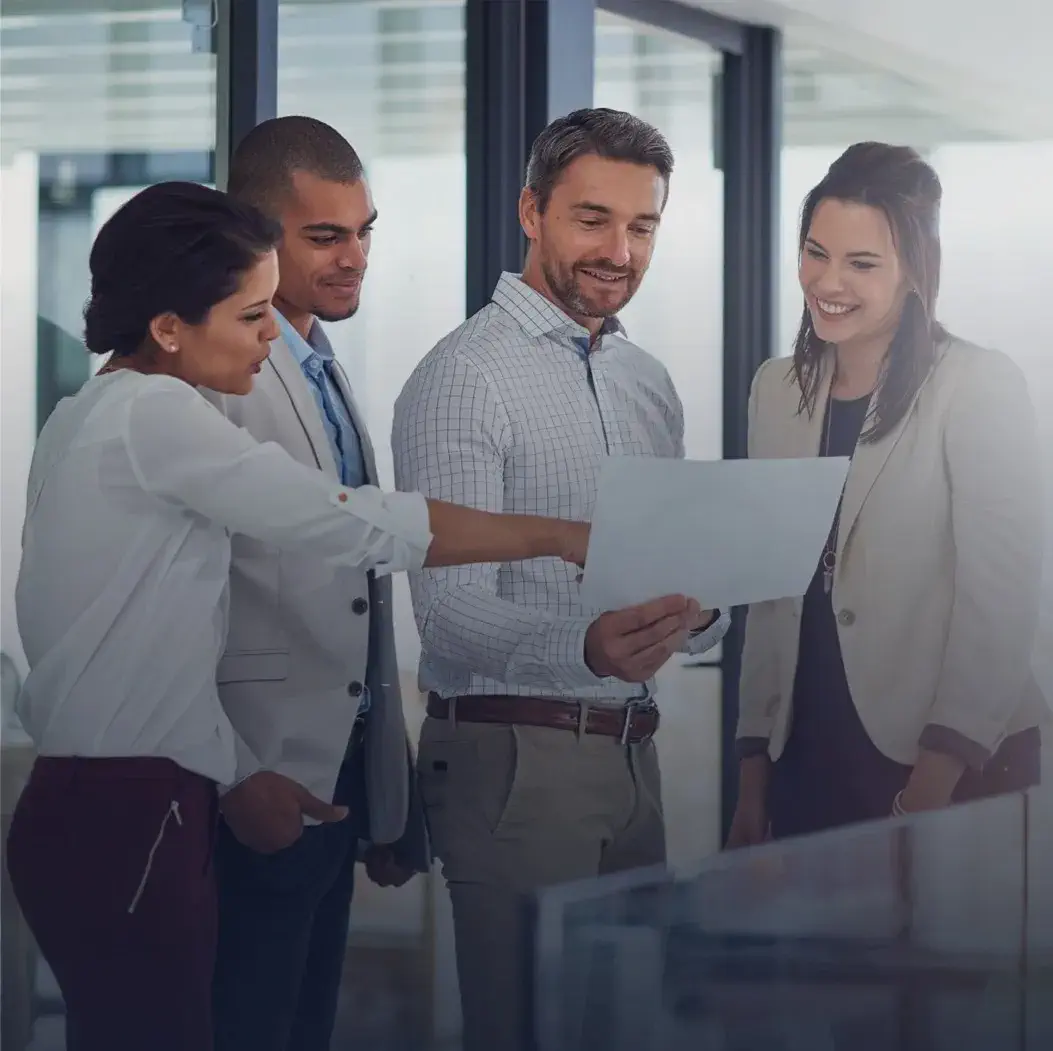 Groupe de professionnels analysant un document en réunion – développement des capacités, gestion de projet, leadership collaboratif